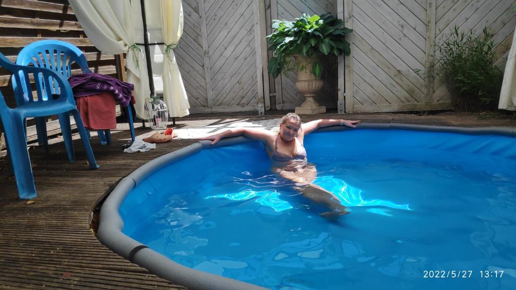 辛根FeWo bei Tati - Bungalow的一个人躺在游泳池里