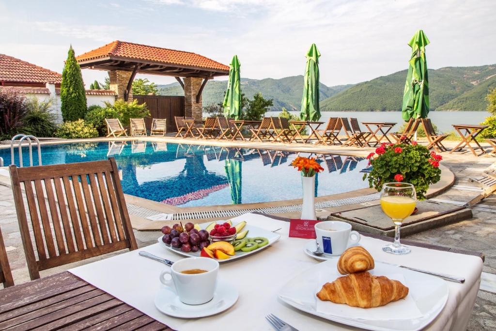 格拉瓦塔斯Family Hotel Saint Konstantin的一张桌子,旁边是游泳池,提供早餐食品和饮料
