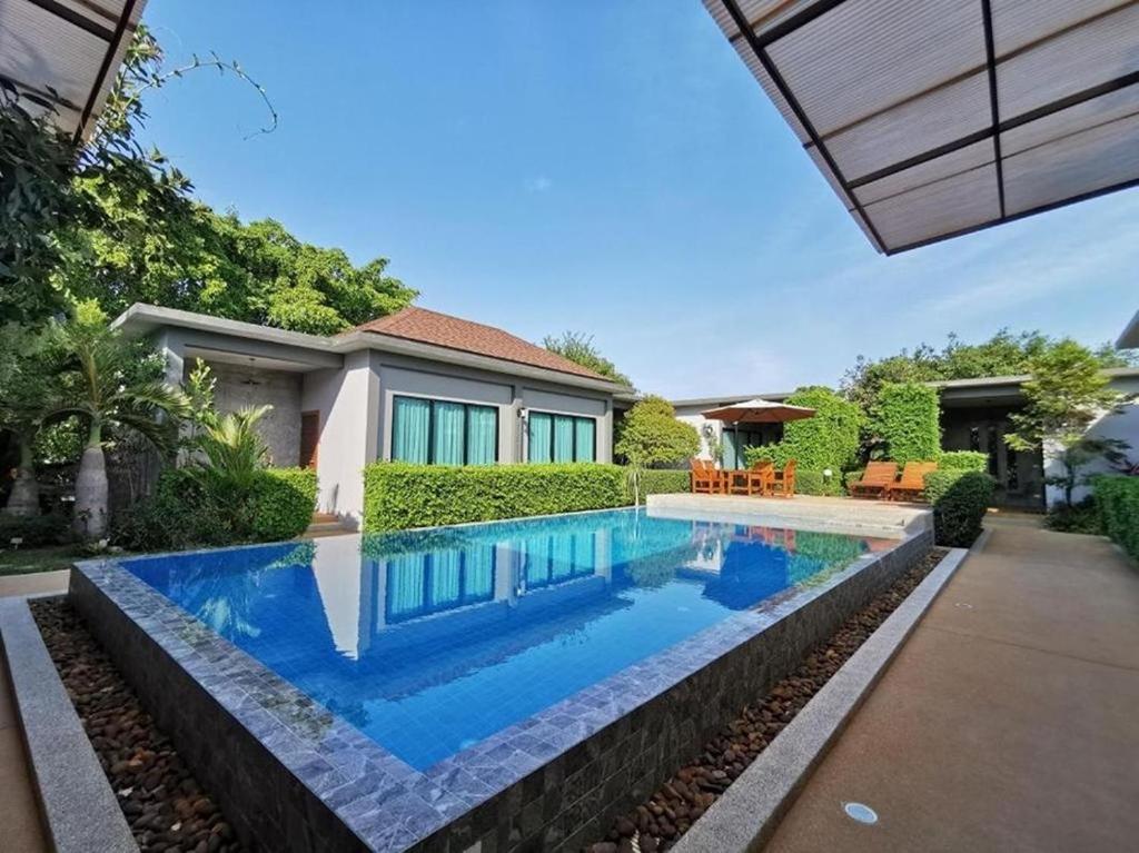 查龙BaanMee Phuket SHA Plus的一座房子后院的游泳池