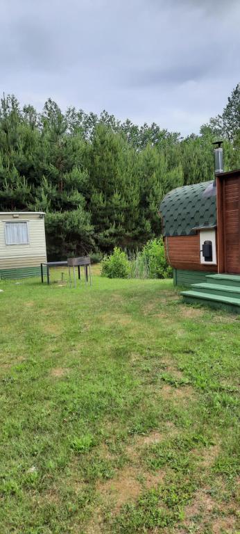 尼察Lini Guest House的草地上带房子和长凳的院子