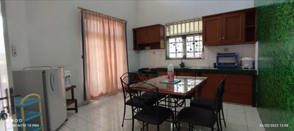 不拉士打宜Villa Berastagi Mas的厨房配有桌椅和冰箱。