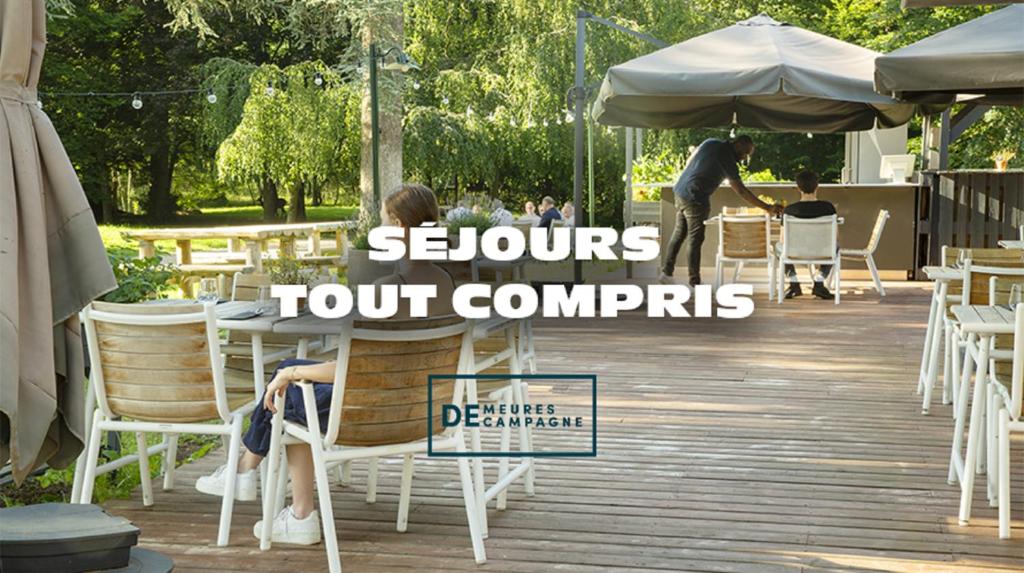 勒库德雷·蒙特考克斯Demeures de Campagne Parc du Coudray - Barbizon的坐在桌子上的女人