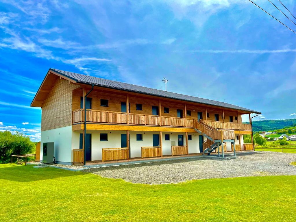 瓦拉什斯凯梅济日奇Sport HOTEL Bečva的一座带绿色草坪的大型木质建筑