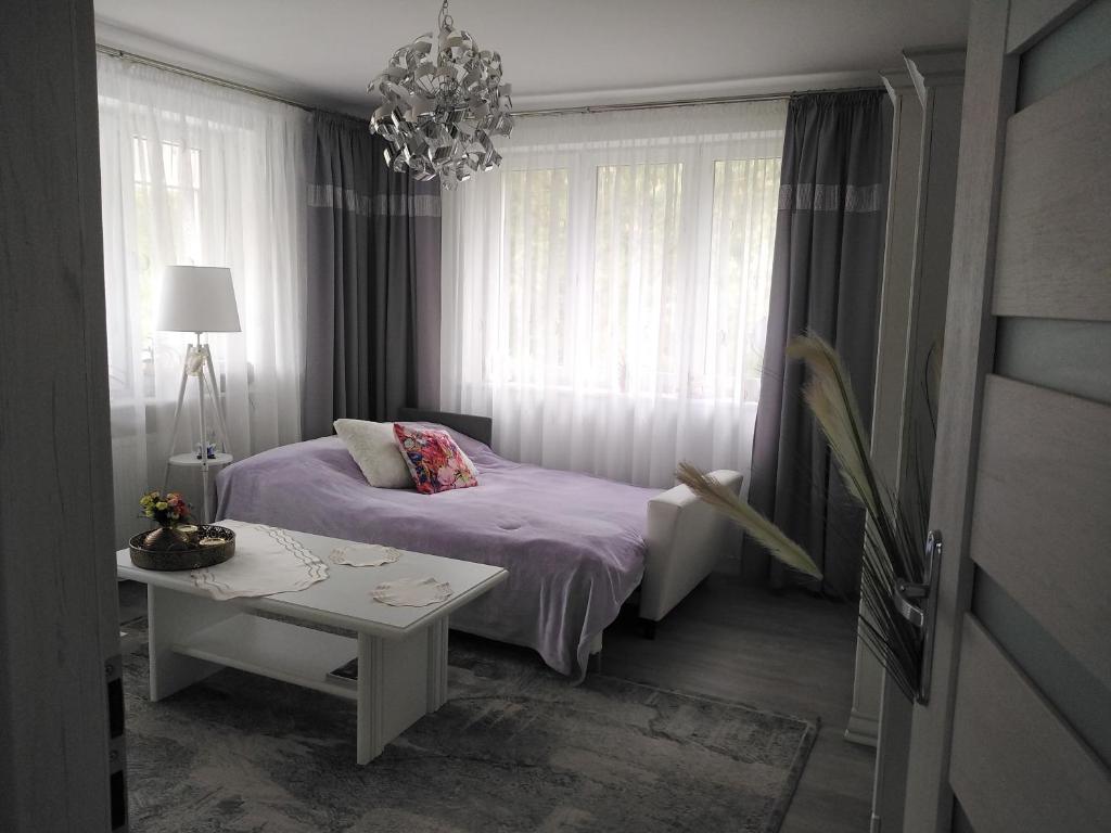 奥尔什丁Pokoje gościnne Słupy Olsztyn - parking的一间卧室配有一张床、一张桌子和一个吊灯。