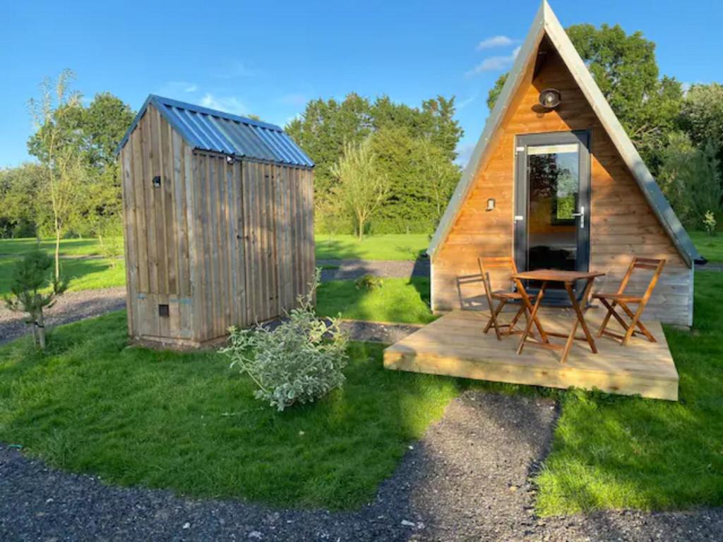 汤顿Countryside Cabin的小屋在草地上配有桌椅