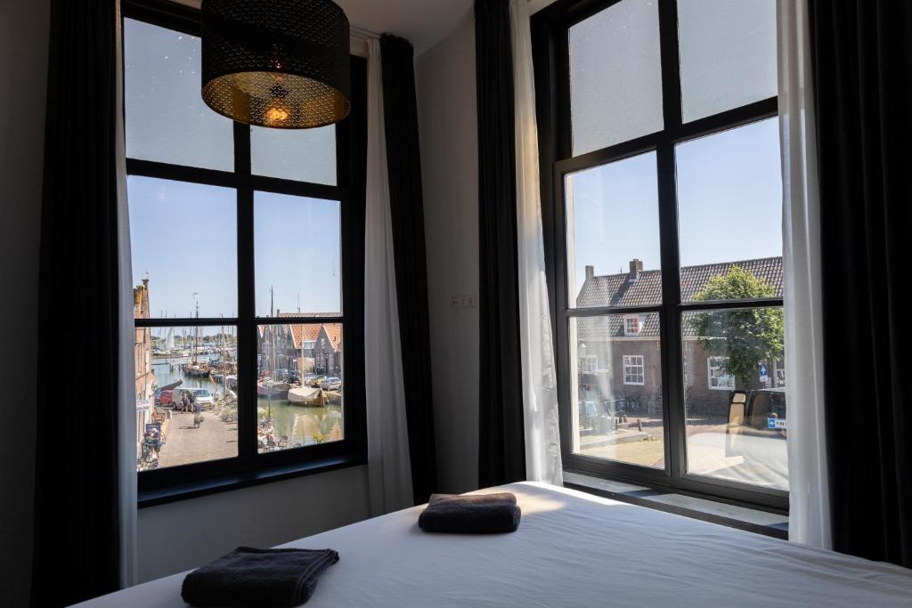蒙尼肯丹Hotel Monnickendam的一间卧室配有2个枕头,设有2个窗户。