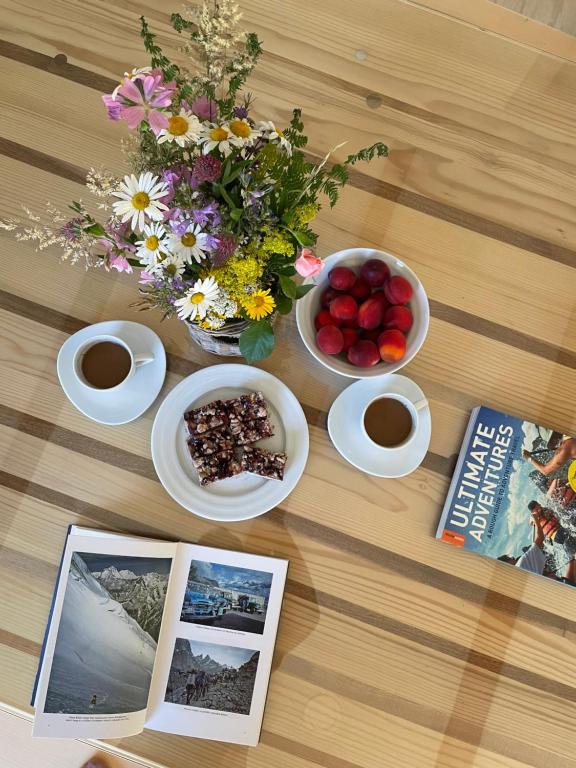 Bosanski PetrovacMountain Heart House的一张桌子,上面放着一碗水果和鲜花,还有一本书