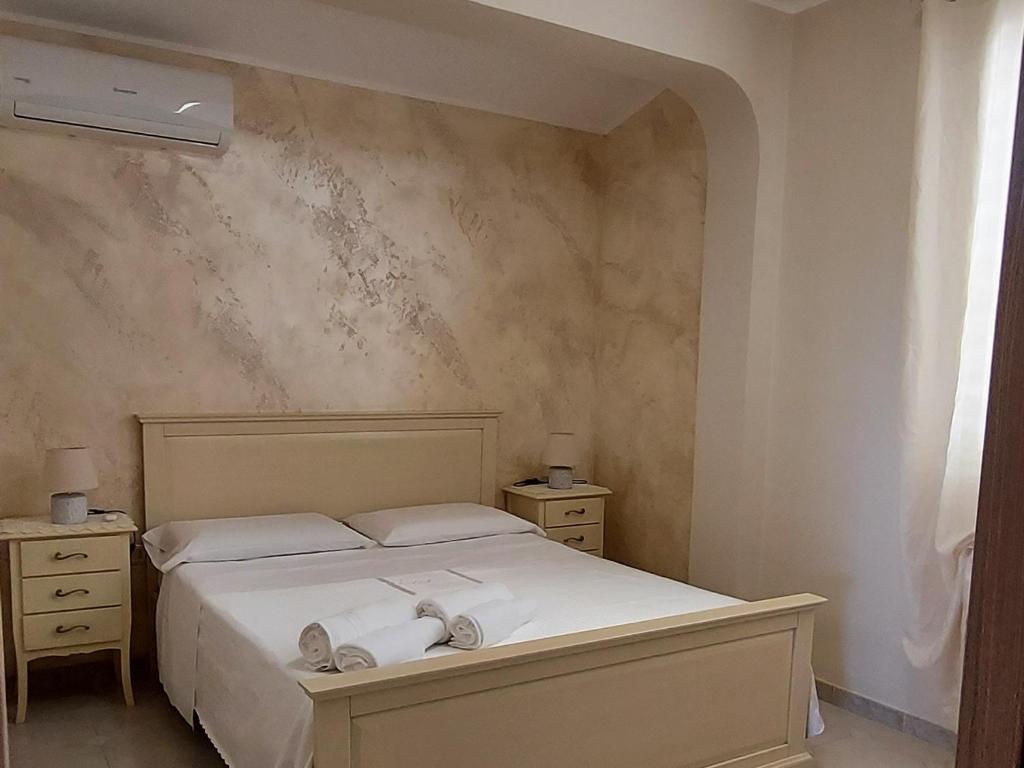 兰佩杜萨LA PERGOLA的一间卧室配有一张床,上面有两条毛巾
