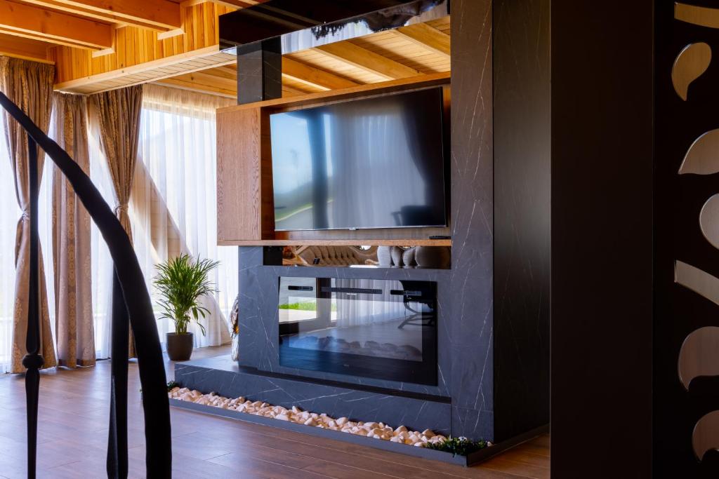 OrllanBatllava Premium Resort Villa 1的客厅的墙上配有电视