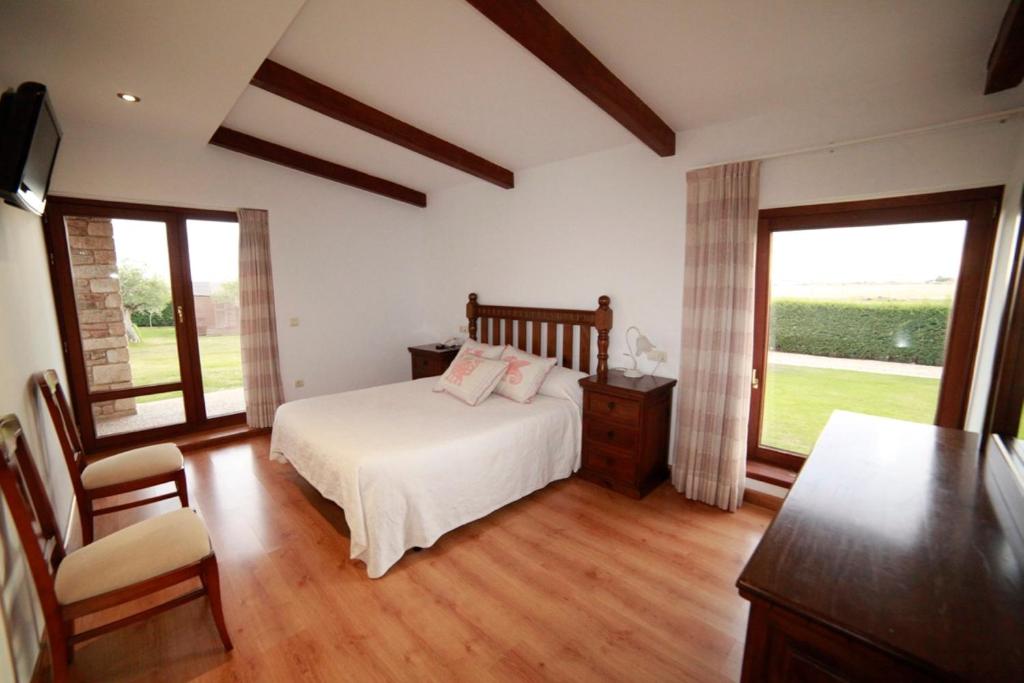 Vitigudino拉托尔托拉度假屋的一间卧室设有一张床和两个窗户。