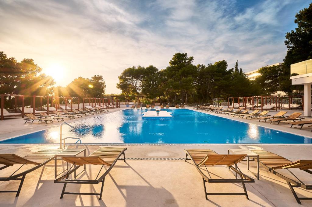 沃迪切Hotel Imperial的一个带椅子和阳光的大型游泳池