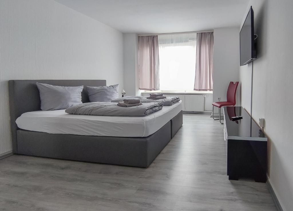 卡塞尔泽林内霍夫旅馆的一间卧室配有一张大床和一张红色椅子