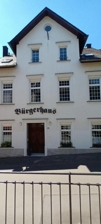 策尔廷根-拉蒂希Buergerhaus Zeltingen Fewo的前面有门的白色建筑