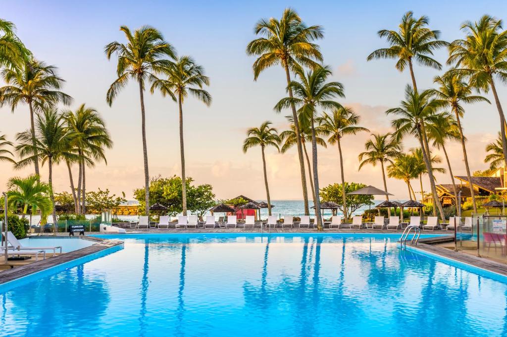 哥西尔拉克里奥尔海滩酒店及水疗中心的一座棕榈树和海洋游泳池