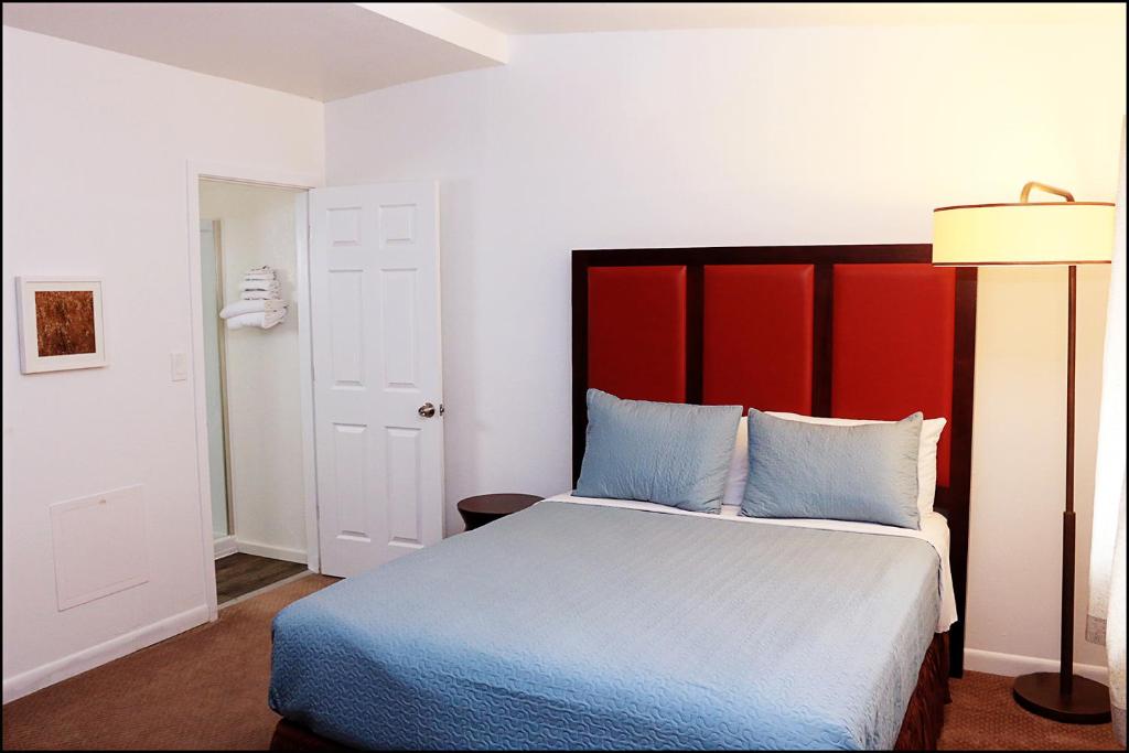 KemmererAntler Motel的一间卧室配有一张大床和红色床头板