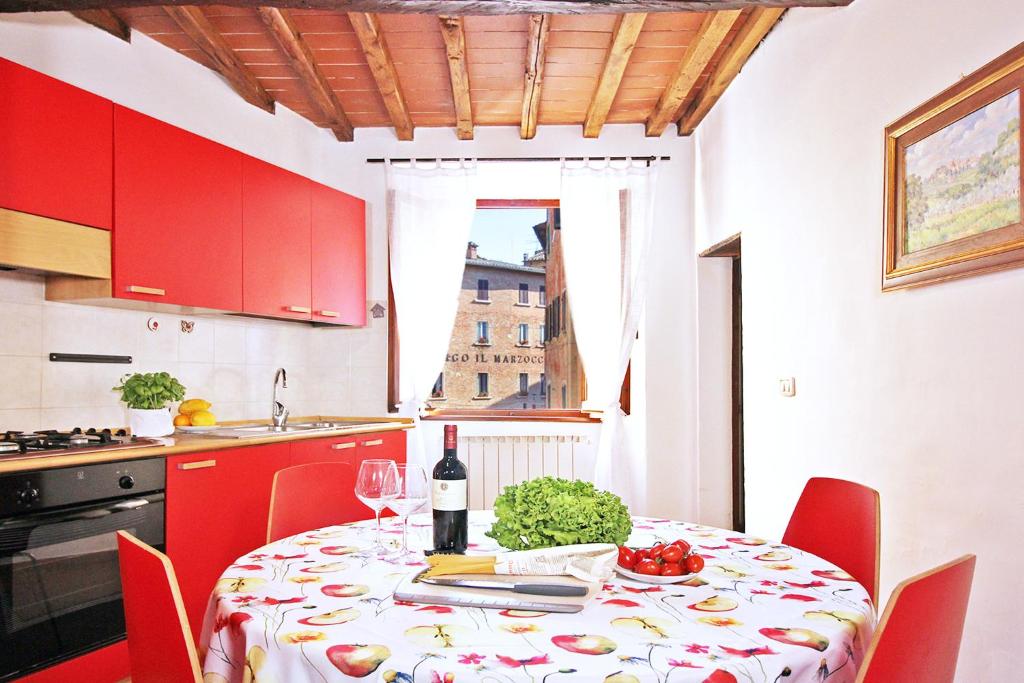 蒙特普齐亚诺Girolamo Apartment - Super Central, Private Parking & Outdoor Area的厨房配有带1瓶葡萄酒的桌子