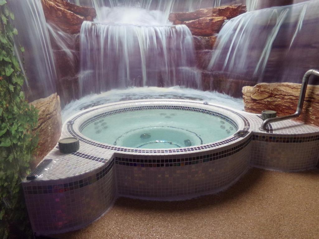 洛翁普拉日chambre avec spa privatif的瀑布前的热水浴池