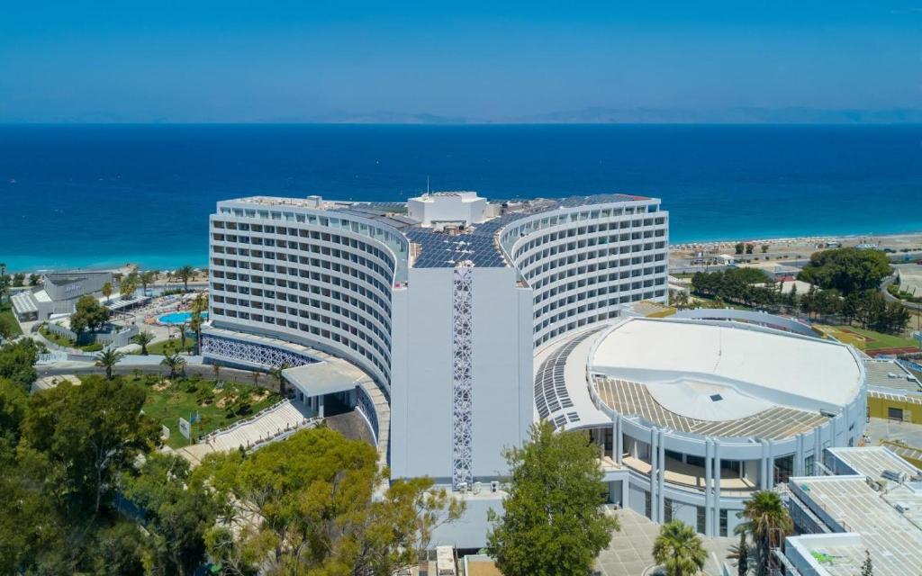 依克希亚Akti Imperial Deluxe Resort & Spa Dolce by Wyndham的毗邻大海的白色大建筑