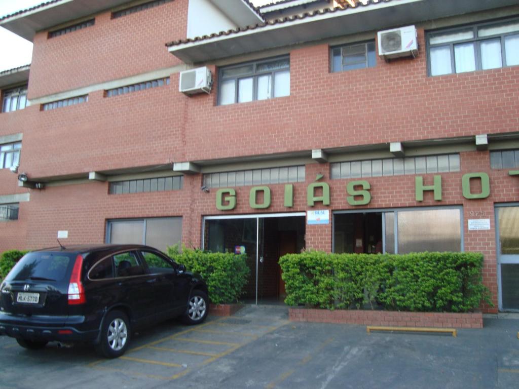 戈亚尼亚戈亚斯酒店的停在大楼前停车场的汽车