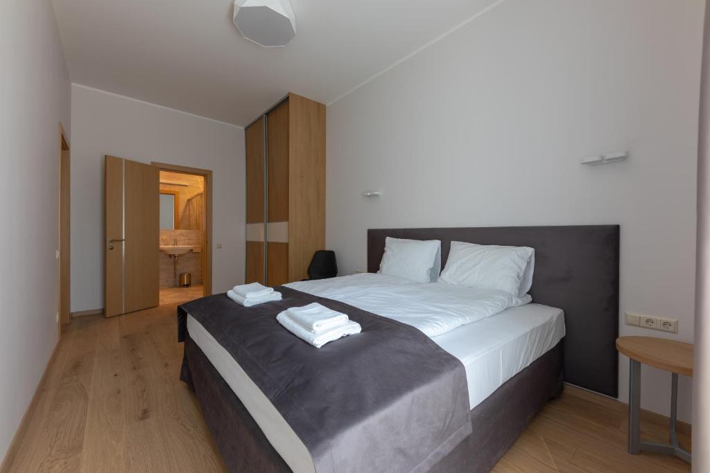 尤尔马拉Oasis Apartments的一间卧室配有一张大床和两条毛巾