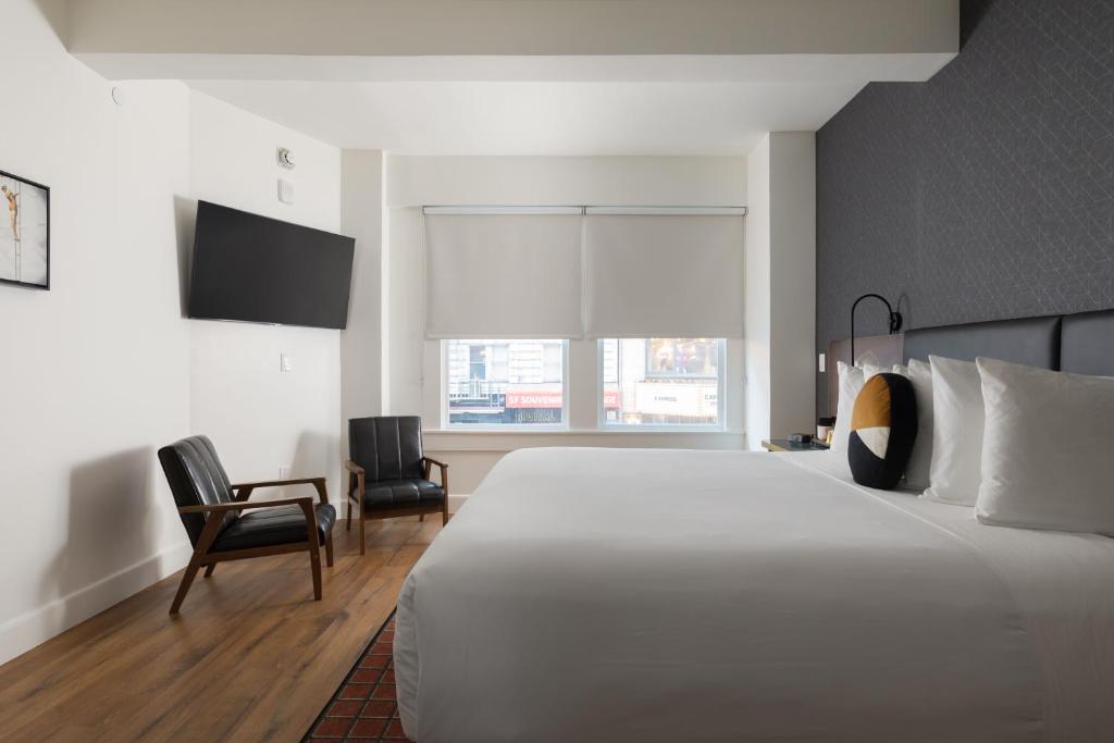 旧金山斯特拉特福德酒店的卧室配有一张白色大床和两把椅子