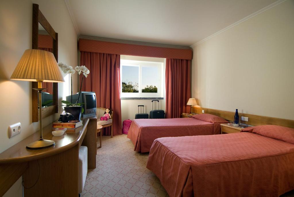 法蒂玛克鲁兹阿尔塔酒店的酒店客房设有两张床和电视。