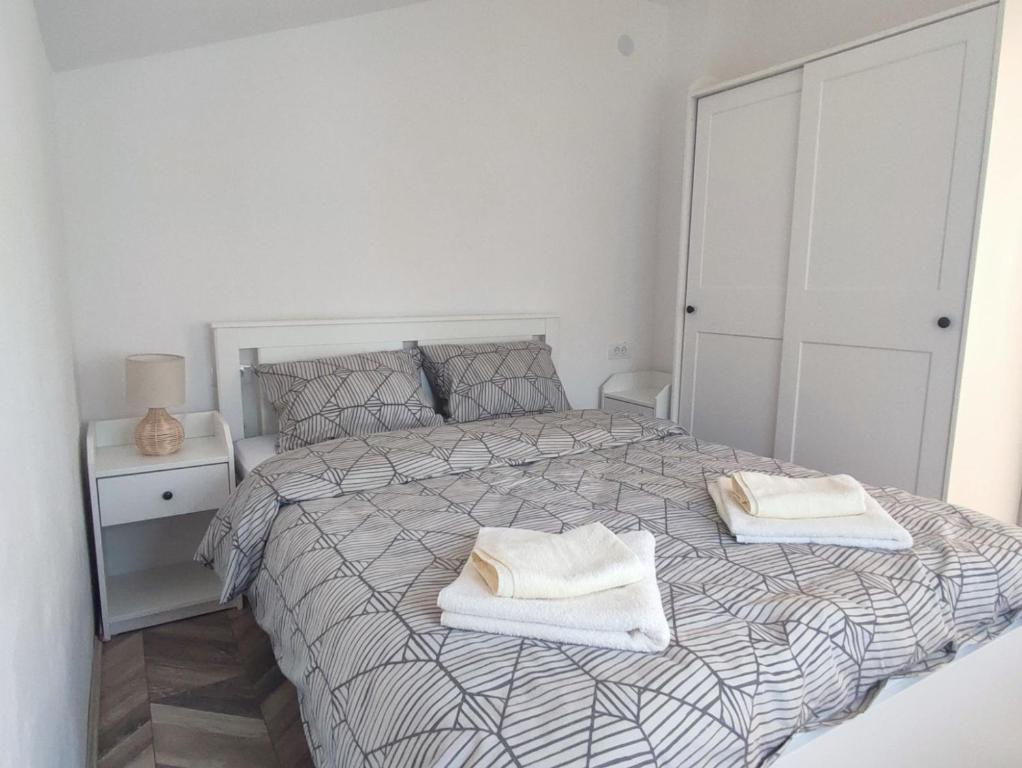 维尔蒂尼克Apartman Flora Vrdnik的白色卧室配有带2条毛巾的床
