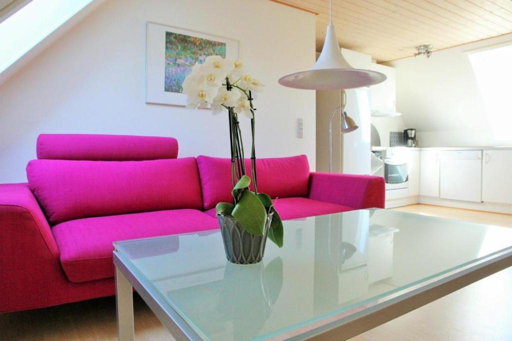 伦讷Bornholm Majalis的客厅配有粉红色的沙发和玻璃桌
