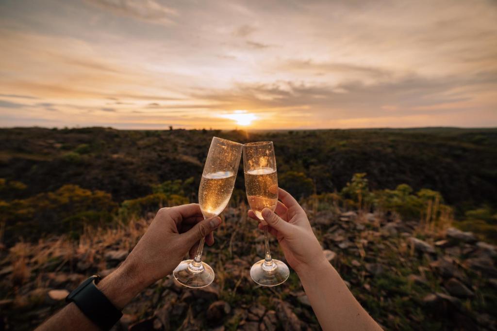 凯瑟琳Gorge View Bush Retreat : Katherine NT的两人在日落前戴香槟酒杯