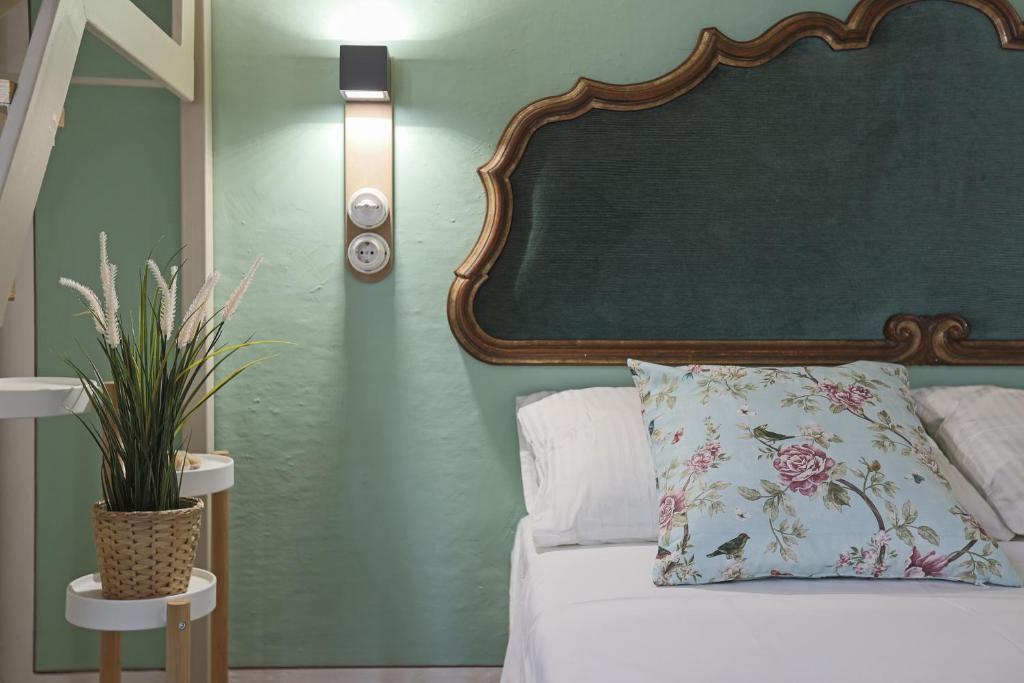 阿斯蒂Donna Elena - Epoque Residence的一间卧室配有一张带绿色墙壁的床