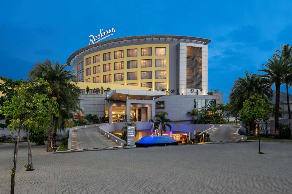 塞勒姆塞勒姆丽筠酒店的一座酒店大楼前面有棕榈树