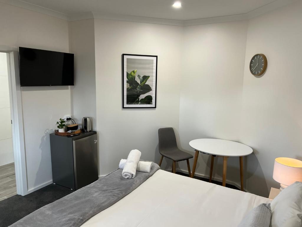 本迪戈BENDIGO BOTANIC MOTEL- with KING BEDS-REFURBISHED 2022的一间卧室配有一张床、一张桌子和闹钟