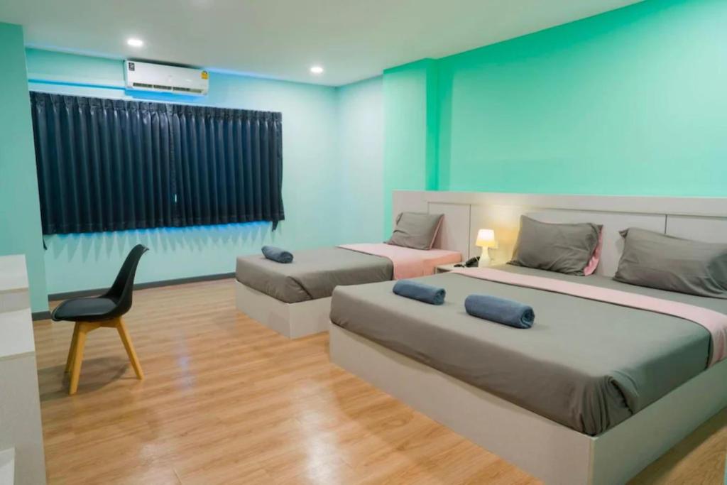 Ban Khlong WaSritrang Residence的一间设有两张床和椅子的房间