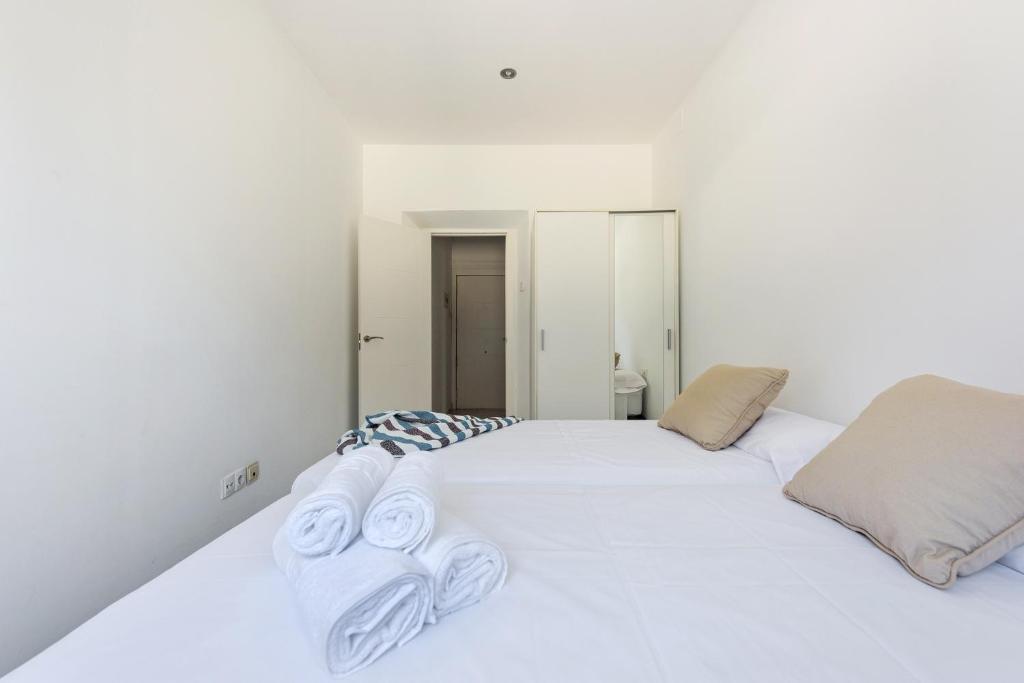 格拉纳达Apartamento Alborea的卧室配有白色床和毛巾