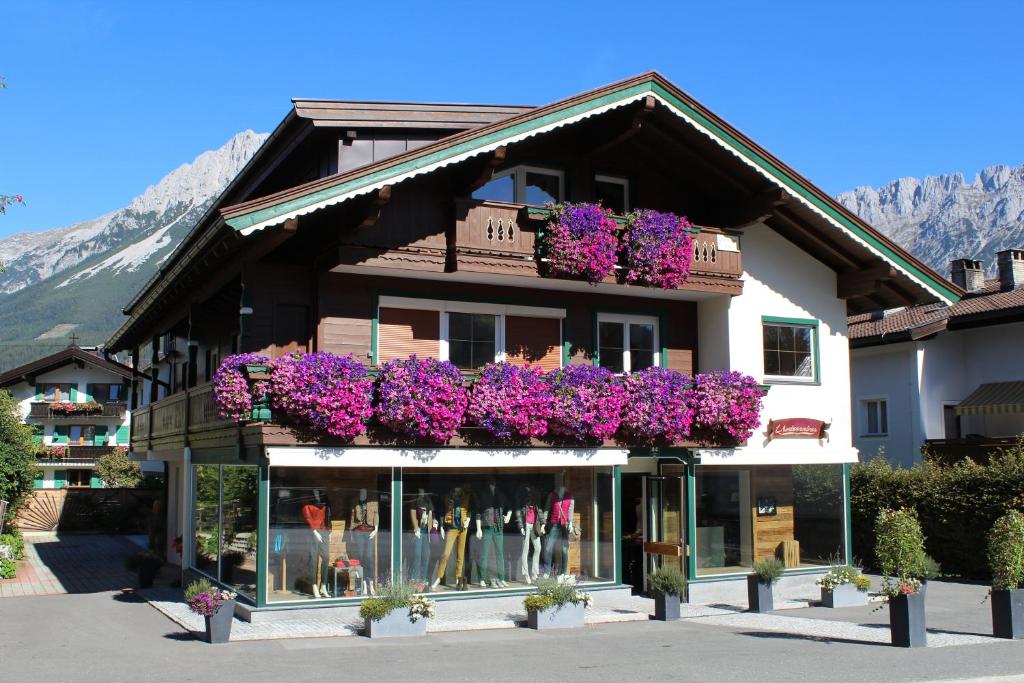 埃尔毛Alpking Hostel的一座建筑边布满紫色花的商店