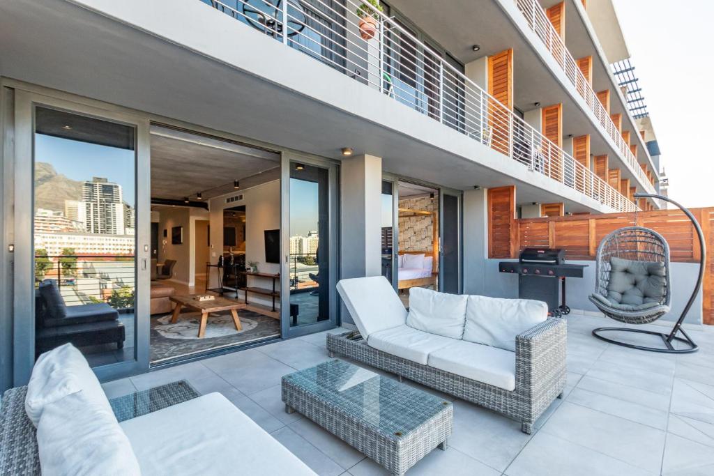 开普敦Docklands Luxury Two Bedroom Apartments的阳台设有带沙发和椅子的客厅
