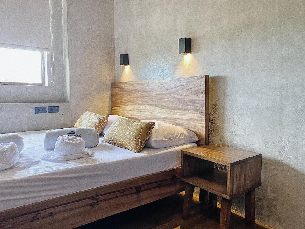 san juan la unionShorebreak Hostel San Juan La Union的一张带木头床头板和桌子的床