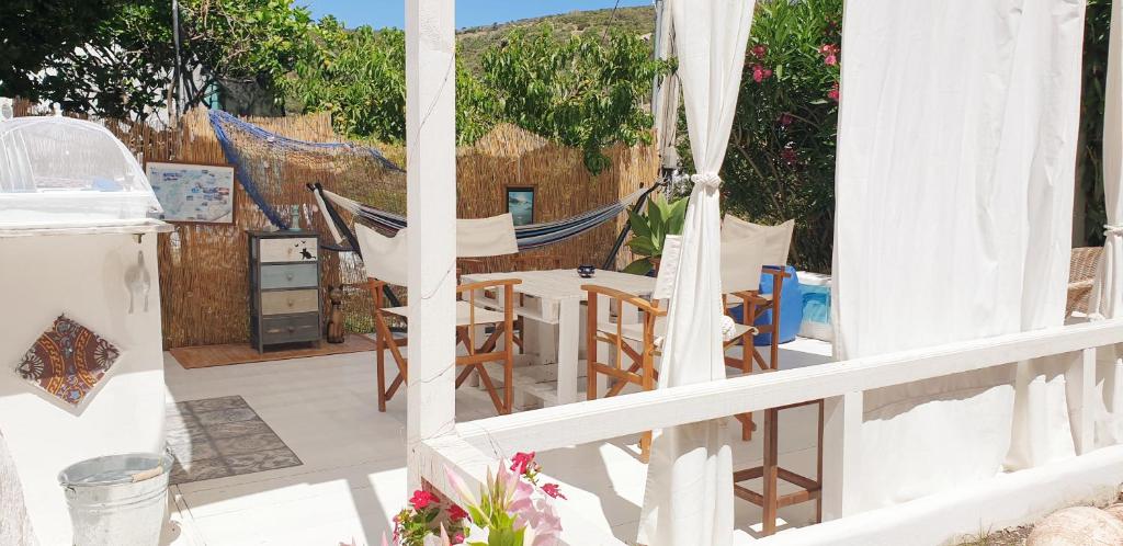 蓬扎La casa Rosa的阳台配有吊床和桌椅。