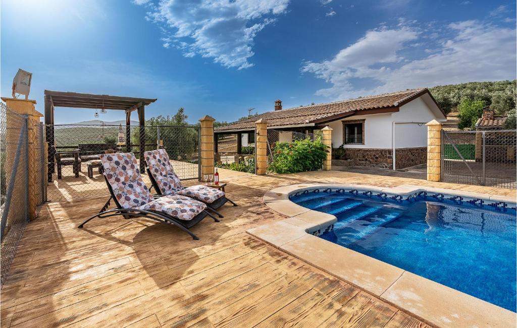 蒙特弗里奥Amazing Home In Montefro With Swimming Pool的一个带两把椅子的庭院和一个游泳池