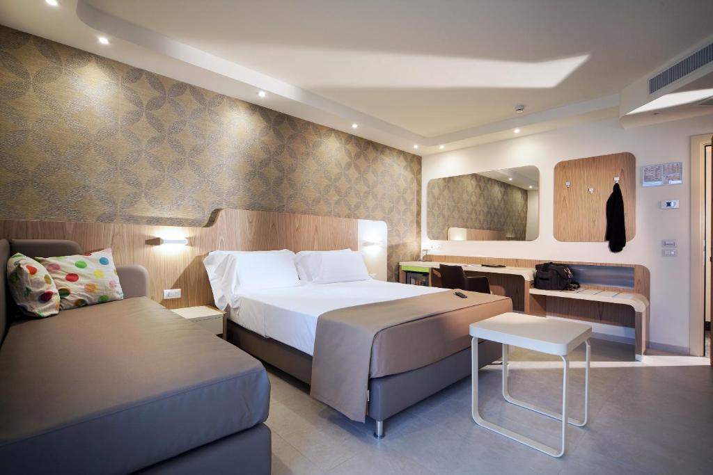 里米尼阿丽亚酒店的酒店客房,配有床和沙发