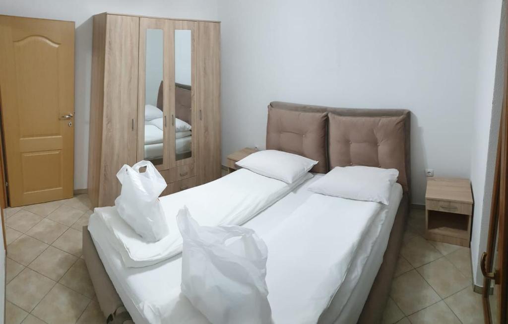 Apartmani Kuprešak的一间卧室配有两张带白色床单和镜子的床