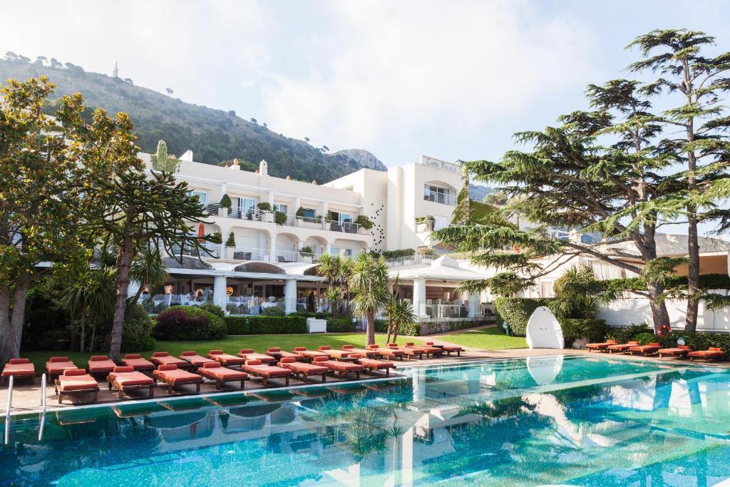 阿纳卡普里Jumeirah Capri Palace的一座带游泳池和椅子的酒店和一座建筑