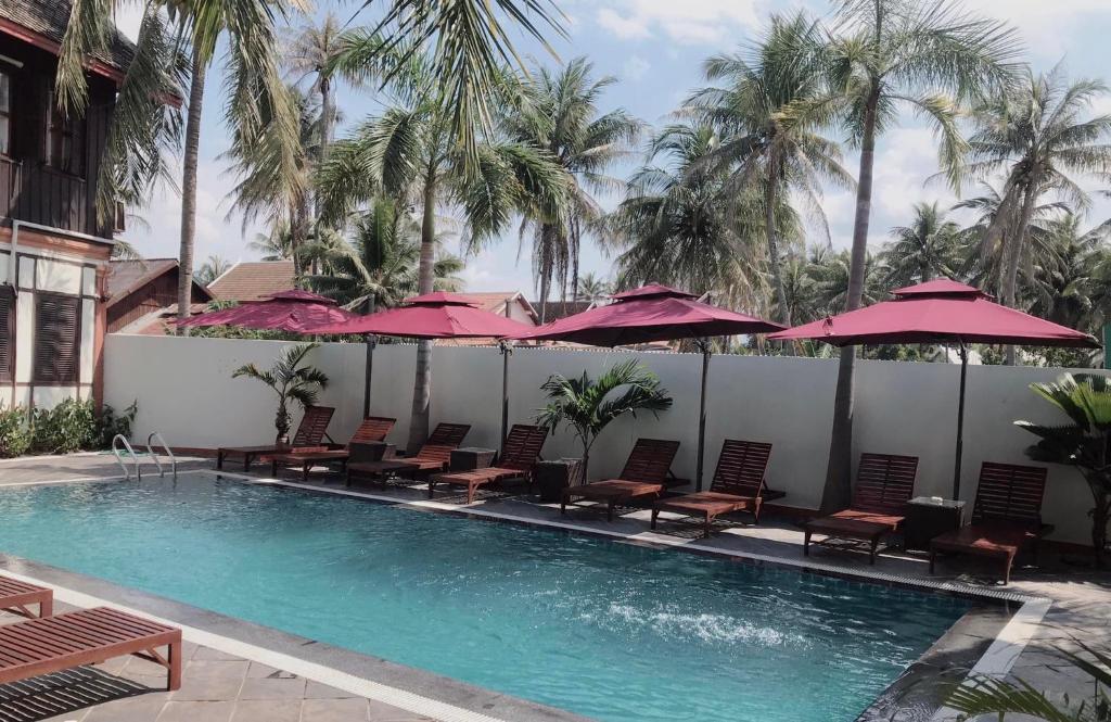 琅勃拉邦马哈索克别​​墅酒店的一个带椅子和遮阳伞的游泳池