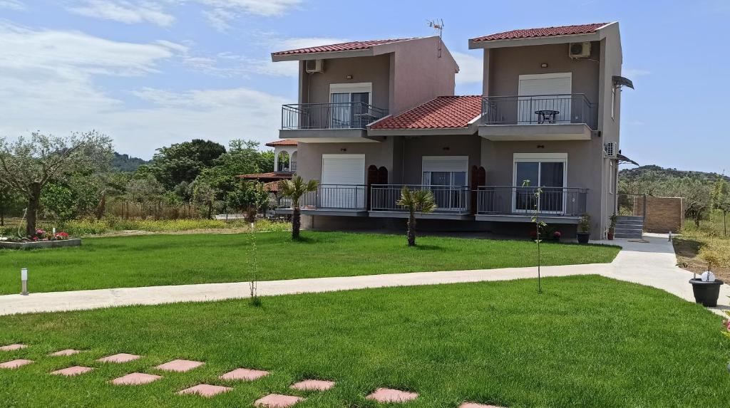 奥马斯帕纳吉亚斯Vot villas的前面有绿色草坪的房子