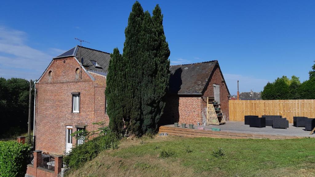 ProisyLes Hauts de Proisy的前面有树的砖房