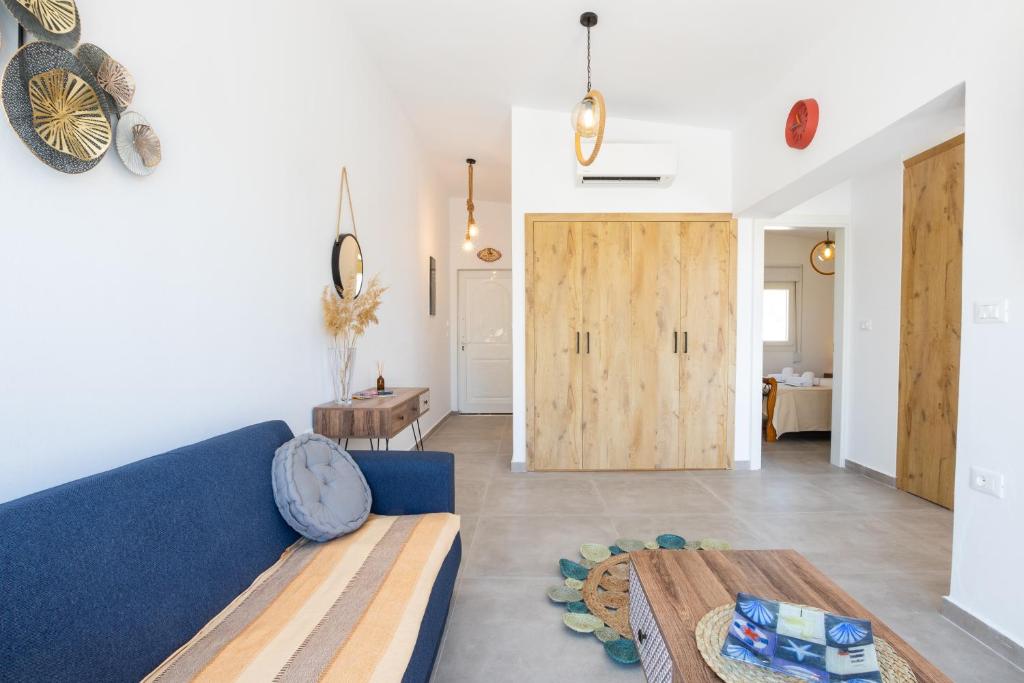 卡尔帕索斯Aronia Luxury Apartments Karpathos的客厅设有蓝色的沙发和木门。