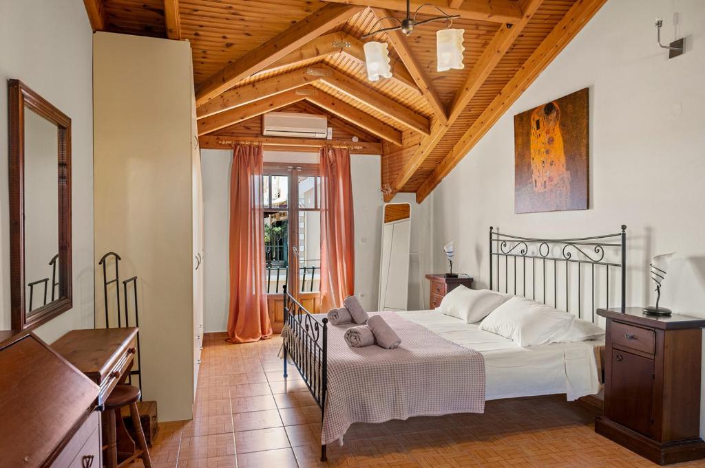 阿尔戈斯托利翁La Casetta的卧室设有白色的床和木制天花板。