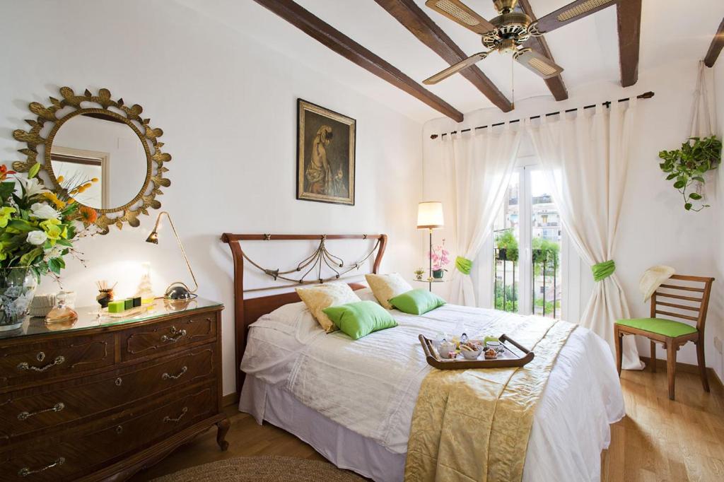 巴塞罗那埃伊桑普雷康福特公寓的一间卧室配有一张带梳妆台和镜子的床