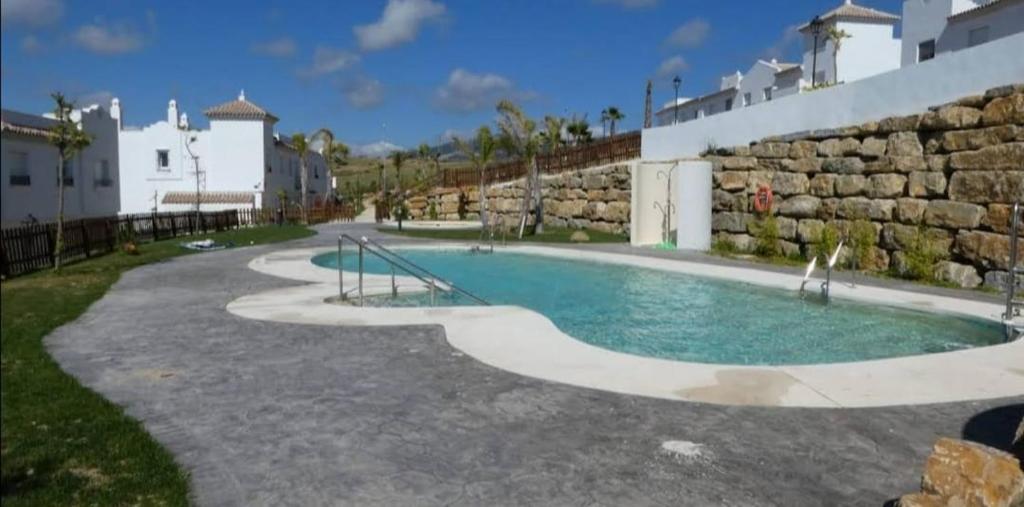 萨阿拉德洛斯阿图内斯Agradable casa adosada con piscina的大楼前的游泳池