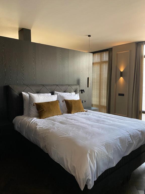 NistelrodeBrabant Suites的卧室配有一张带黄色枕头的大型白色床。
